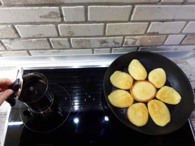  Bir tavada krep ve siyah bir ocakta kahve makinesinde taze demlenmiş kahve.