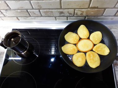  Bir tavada krep ve siyah bir ocakta kahve makinesinde taze demlenmiş kahve.