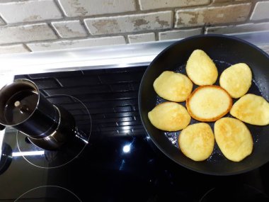 Bir tavada krep ve siyah bir ocakta kahve makinesinde taze demlenmiş kahve.