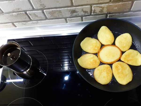  Bir tavada krep ve siyah bir ocakta kahve makinesinde taze demlenmiş kahve.