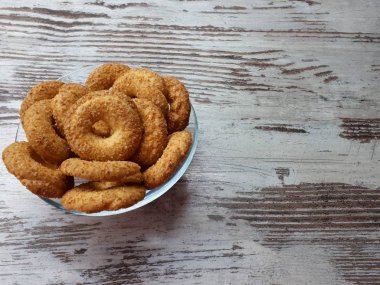  Kurabiye yakın plan, lezzetli, ev yapımı, taze, küçük ekmek, şeker serpiştirilmiş, soyut ahşap bir zemin üzerinde cam bir tabakta