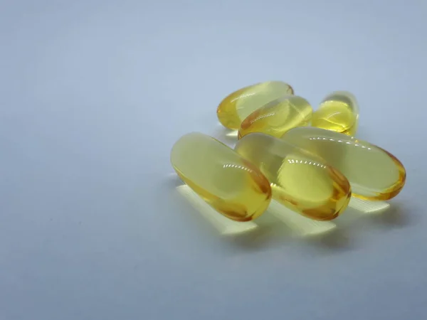 Nahaufnahme Eines Medikaments Nahrungsergänzungsmittels Gelbe Gelatinekapseln Auf Isoliertem Hellen Hintergrund — Stockfoto