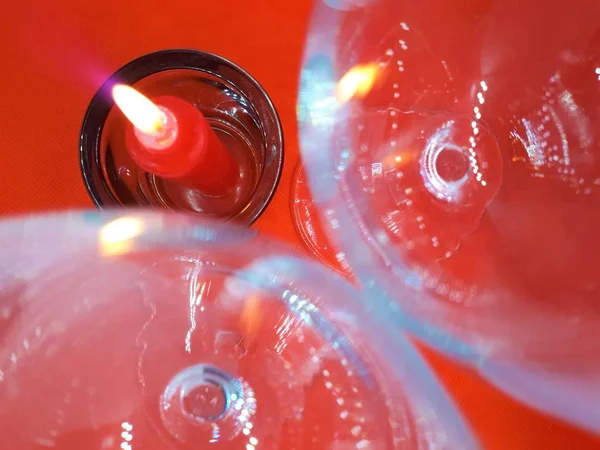 Bokeh效应 水晶眼镜和红色抽象背景上的红色蜡烛烛台 — 图库照片