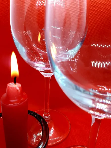 Bokeh效应 水晶眼镜和红色抽象背景上的红色蜡烛烛台 — 图库照片
