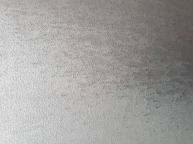 Bokeh efekti ve karakteristik kaba gözenekli dokusu, soyut koyu ve aydınlık lekeleri olan dekoratif bir duvarın yakın çekimi.