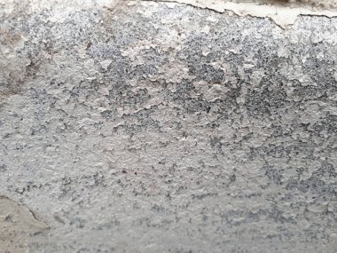  Betondan yapılmış dekoratif bir duvarın, karakteristik kaba, gözenekli bir dokusu, soyut koyu ve aydınlık lekeleri var.