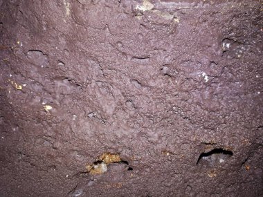 Bokeh efekti ve karakteristik kaba gözenekli dokusu, soyut koyu ve aydınlık lekeleri olan dekoratif bir duvarın yakın çekimi.