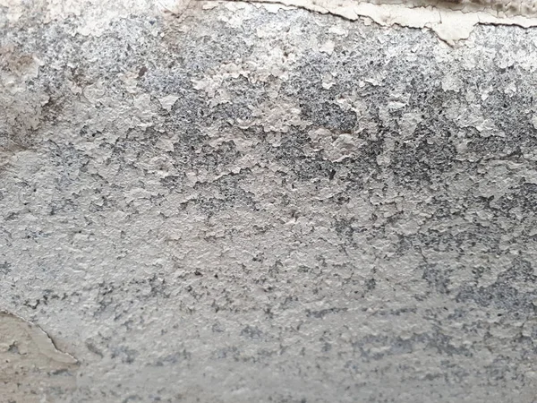 close-up of a decorative wall made of concrete, with a characteristic rough porous texture, abstract dark and light stains