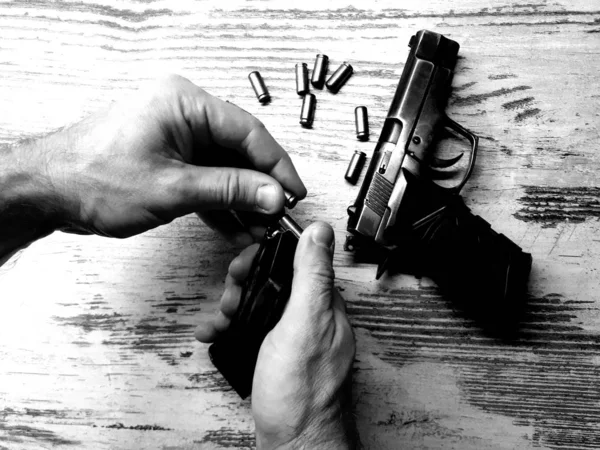 close-up weapons, a black traumatic gun that shoots rubber bullets in the hand of a man / woman