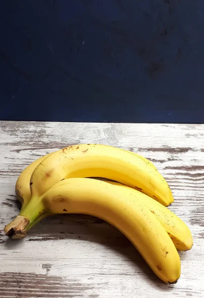 Nahaufnahme Von Gelben Reifen Bananen Auf Einer Abstrakten Holzoberfläche — Stockfoto