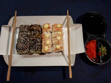 Soyut bir yüzeyde soya soslu bir suşi setinin yakın çekimi.