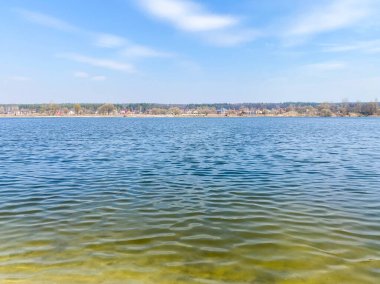 Mavi gökyüzünün arka planında büyük bir göle yakın çekim.