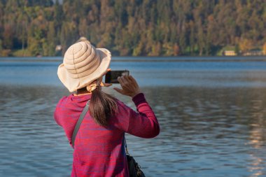 Elinde cep telefonu olan ve fotoğraf çeken kadının arka plan görüntüsü.