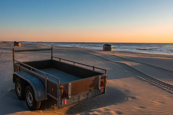 Camper or trailer on sandy sea beach in beautiful sunset with serene seaside in the background — ストック写真