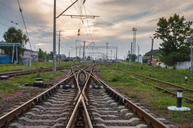 Gün batımında güzel gökyüzüne karşı iki tren yolu birleşir..