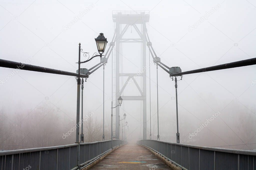 Bridge in a dense fog. Concept of solitude and serenity. Mystical and mysterious landscape