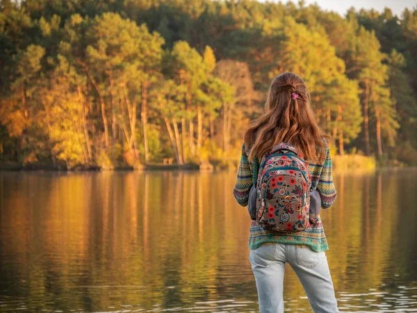 Vista trasera de la chica con mochila de pie cerca del río —  Fotos de Stock