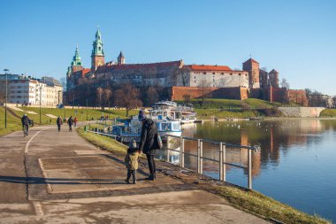 Krakow, Polonya - 3 Ocak 2018: Krakow kentindeki Wawel kalesine giden yolda çocuklu anne