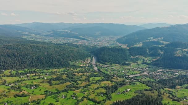 Uitzicht vanuit de lucht op bergdorp met bossen, velden. Karpaten. — Stockvideo