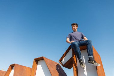 Bir numara konsepti başarıya ulaştırır. Genç bir adam büyük harflerin üzerinde oturuyor.