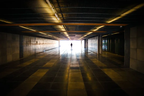 Silhueta de pessoa irreconhecível e luz do dia à frente no túnel do metrô Imagens De Bancos De Imagens