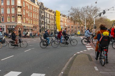 Amsterdam, Hollanda - 2 Nisan 2019: Bisikletçiler bisikletle karşıya geçiyor
