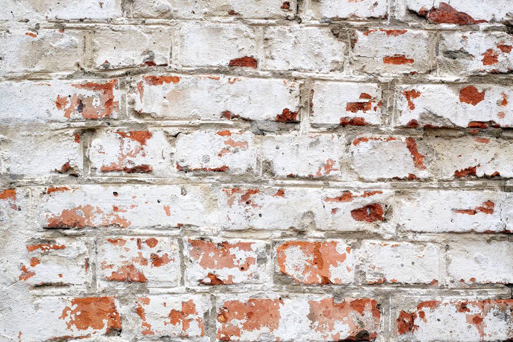 old brick wall with white plaster and red bricks background.