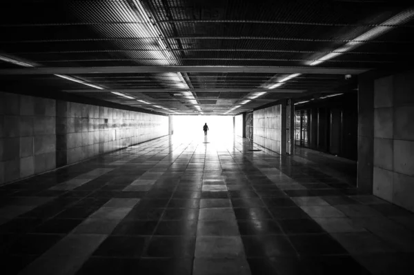 Silhueta de pessoa irreconhecível e luz do dia à frente no túnel do metrô Fotos De Bancos De Imagens Sem Royalties