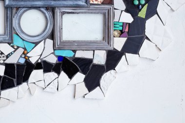 Beyaz duvarın üzerinde seramik parçaları, çerçeveleri, aynaları olan renkli doku, duvar kağıdı ve arkaplan