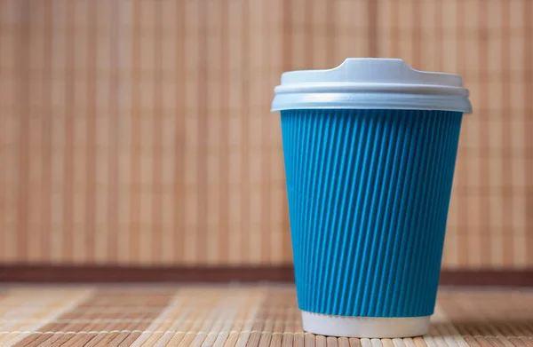 Blått papper eller te kaffe behållare med vitt lock på trä bakgrund. — Stockfoto
