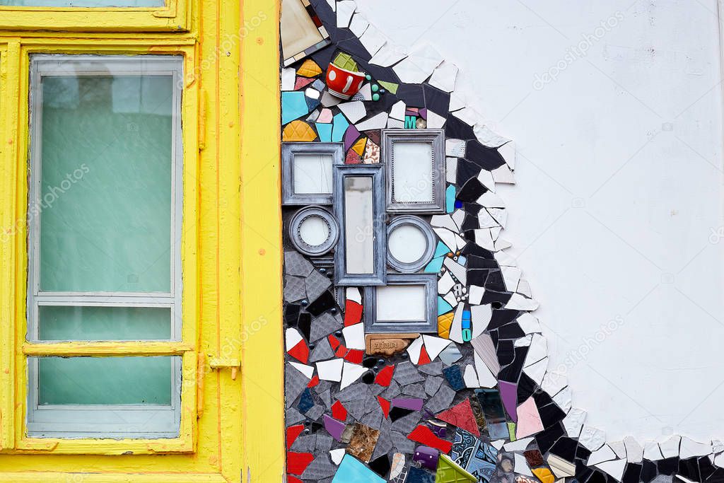 Colorful background with ceramic pieces, mirror parts and frames and bright yellow window