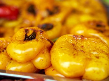 Freshly baked yellow peppers close up. Roasted bell yellow peppers with herbs.