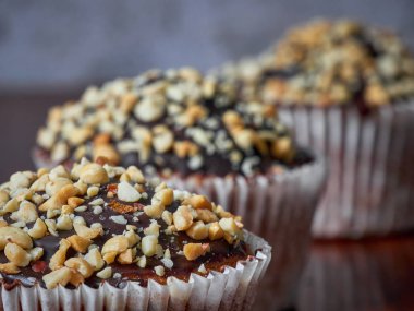 Üç tane fıstık ve çikolata sırasına dizilmiş kek.