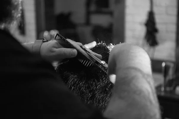 Peluquero profesional haciendo peinado a su cliente en la barbería —  Fotos de Stock