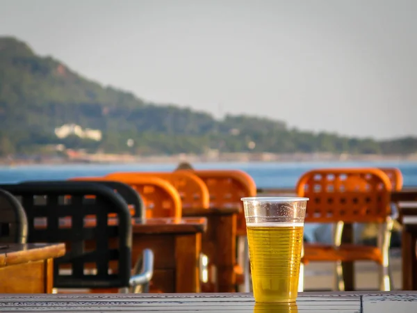 plastic disposable glass of beer on a table of a restaurant on t