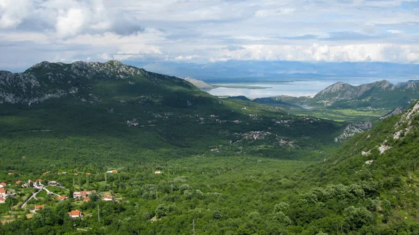 Vista panorámica desde la plataforma de observación en las montañas hasta el lago Skadar y el valle verde, cielo azul, nubes blancas, Montenegro — Foto de Stock