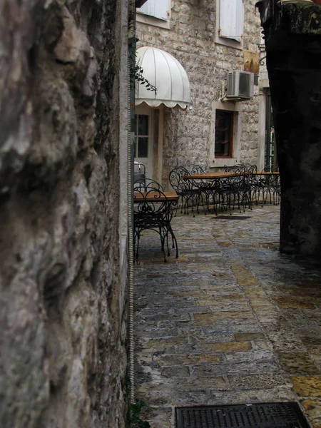 Karadağ 'ın başkenti Kotor' un dar sokaklarındaki kafe masaları yağmurdan sonra — Stok fotoğraf