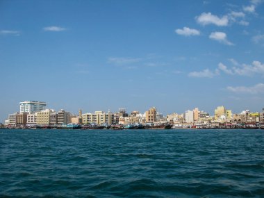 Deira Koyu kıyısındaki modern binalar ve eski moda geleneksel tekneler.