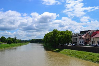 Nehir ve toprak, mavi gökyüzü, beyaz bulutlar, ıhlamur ağaçları, Uzhhorod, Ukrayna