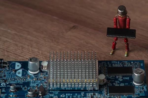 small handmade human figure from resistors helps to assemble modern rugged embedded computer board