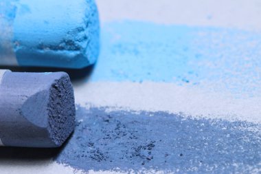 Yeni başlayanlar için yumuşak pastel teknikler. Pastel boya kalemi izi. Kırık tebeşirle kaplanmış mavi tebeşir renginde gri kağıt.