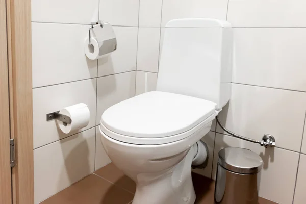 Vaschetta da bagno in ceramica bianca con coperchio chiuso e accessori per la carta igienica in bagno — Foto Stock