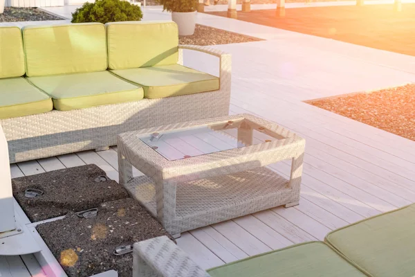 Sofá y mesa de ratán, muebles de exterior en la playa, restaurante de cafetería en la orilla del mar para relajarse y relajarse — Foto de Stock