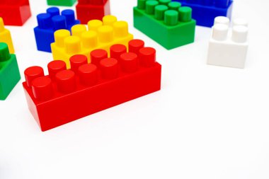 Birçok renkli oyuncak plastik tuğlalar, kopyalama alanı olan beyaz arkaplan üzerine inşa ve inşa etmek için blok kitleri