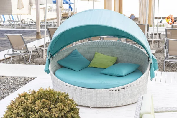 Avkopplande vit rotting säng, soffa med ljusblå och gröna kuddar på stranden, stranden — Stockfoto