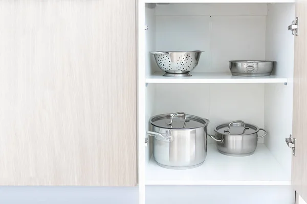 Зберігання сталевих металевих сковорідок та іншого посуду, посуд в шафі сучасної кухні, копіювання простору — стокове фото