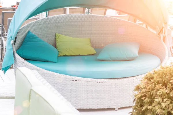 Avkopplande vit rotting säng, soffa med ljusblå och gröna kuddar på stranden, stranden — Stockfoto