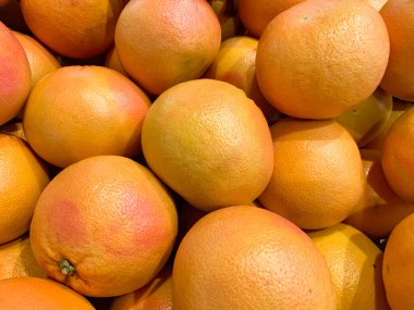 Arka plan olarak süpermarkette bir sürü taze greyfurt, organik vejetaryen yiyecekler, çiftlik pazarında satılık sebzeler.