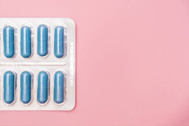 Cinsel yolla bulaşan hastalıklar için antibiyotikler ve antimikrobik haplar. Std, pembe arka planda su toplayan mavi kapsüller, kopyalama alanı.
