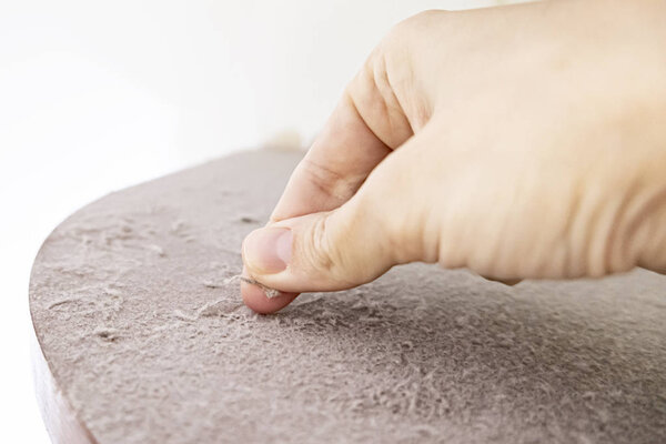 Hand swiping off the dust from dirty furniture, dusty home concept